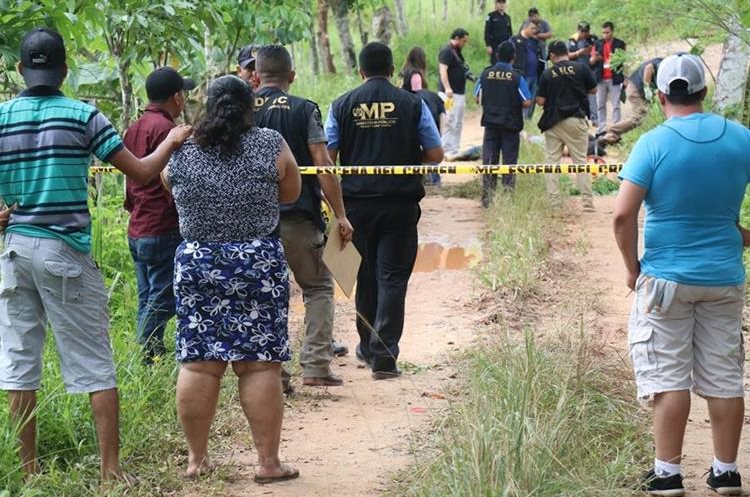 Autoridades trabajan en el lugar donde se presume que abandonaron los cadáveres de tres hombres, en Manaca, Puerto Barrios, Izabal; mientras observan familiares de las víctimas. (Foto Prensa Libre: Dony Stewart)