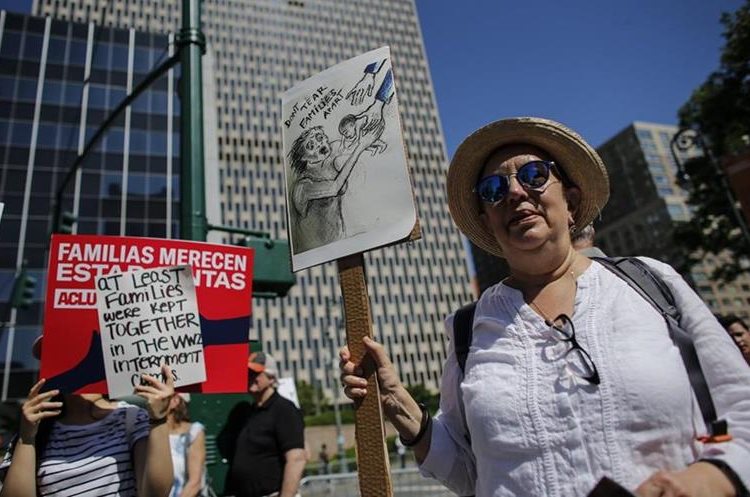   A woman walks through the streets of New York with a sign with the caption: 