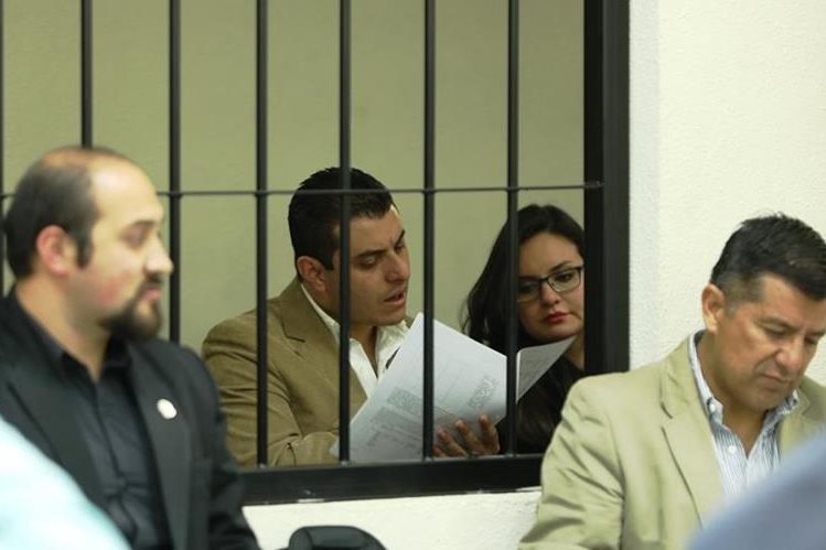 René Arturo Morales y su esposa Carmen Barrientos Salguero, yerno e hija del exalcalde de Xela, leen la acusación que les hace la Fiscalía Especial contra la Impunidad. (Foto Prensa Libre: Mynor Toc)