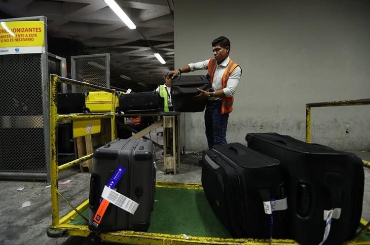 Personal del aeropuerto sube las maletas a un escÃ¡ner de rayos X para ser chequeado y transportado . 