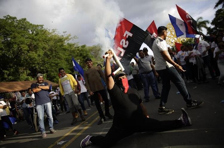   A Nicaraguan uses a mortar lander while supporters of Ortega, and Sandinism crosses the main streets of Managua, Nicaragua. (EFE) 