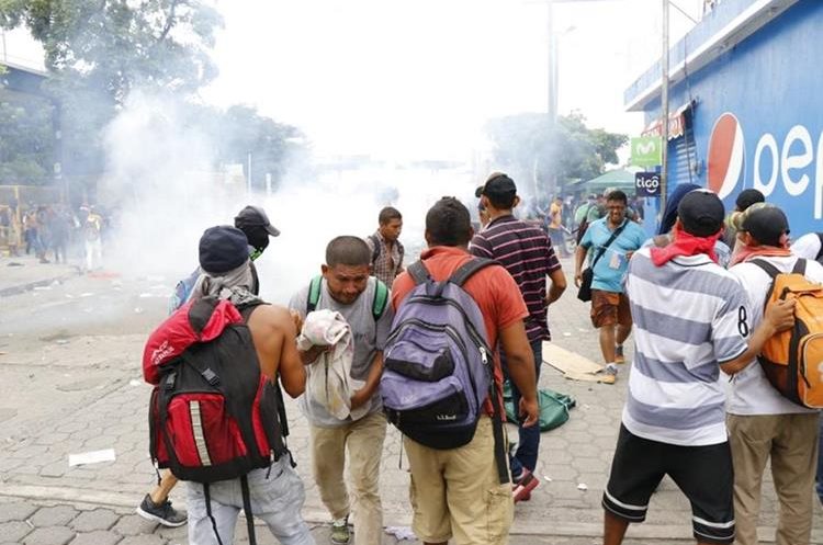 Migrantes hondureños fueron afectados por lo gases lacrimógenos que lanzaron agentes de la Policía Nacional Civi. (Foto Prensa Libre: Rolando Miranda)