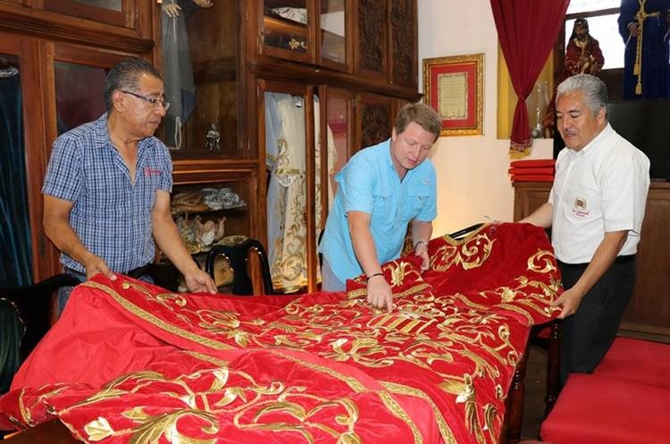 Integrantes de la Hermandad de La Merced muestran la túnica que vestirá la imagen de Jesús Nazareno. (Foto Prensa Libre: Julio Sicán)