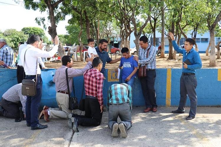 Un grupo de personas ora por el padre para que tenga fuerza, para superar la muerte de su hija. (Foto Prensa Libre: Mario Morales)