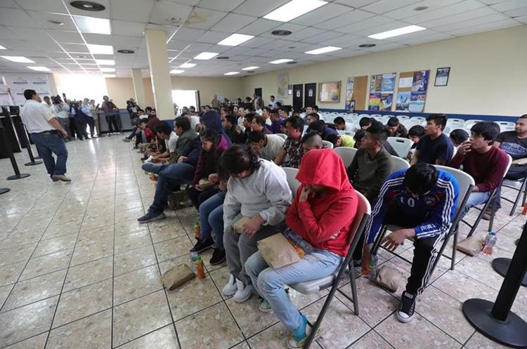 Un grupo de deportados espera ser registrado en la Dirección General de Migración (DGM) en la sede de la Fuerza Aérea Guatemalteca. La DGM solo les provee una pequeña refacción al arriban. (Foto Prensa Libre: Hemeroteca PL)